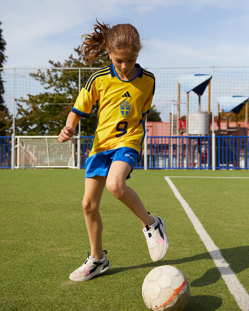 Kinder spielen Fußball auf einer arena.